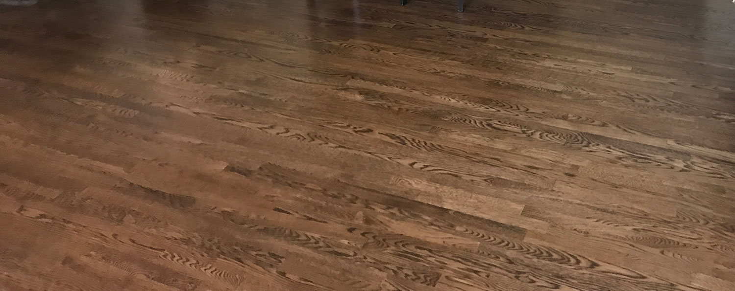 Wide-plank oak hardwood floor across a full room